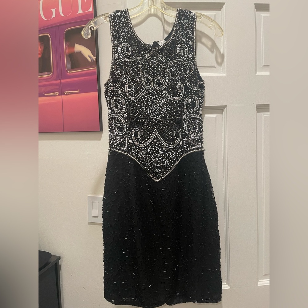 This is a Laurence Kazar black sparkly knee length dress in a size Small
